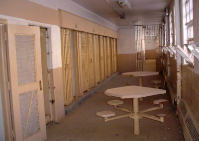 Prison cells and tables outside of them at Old Main