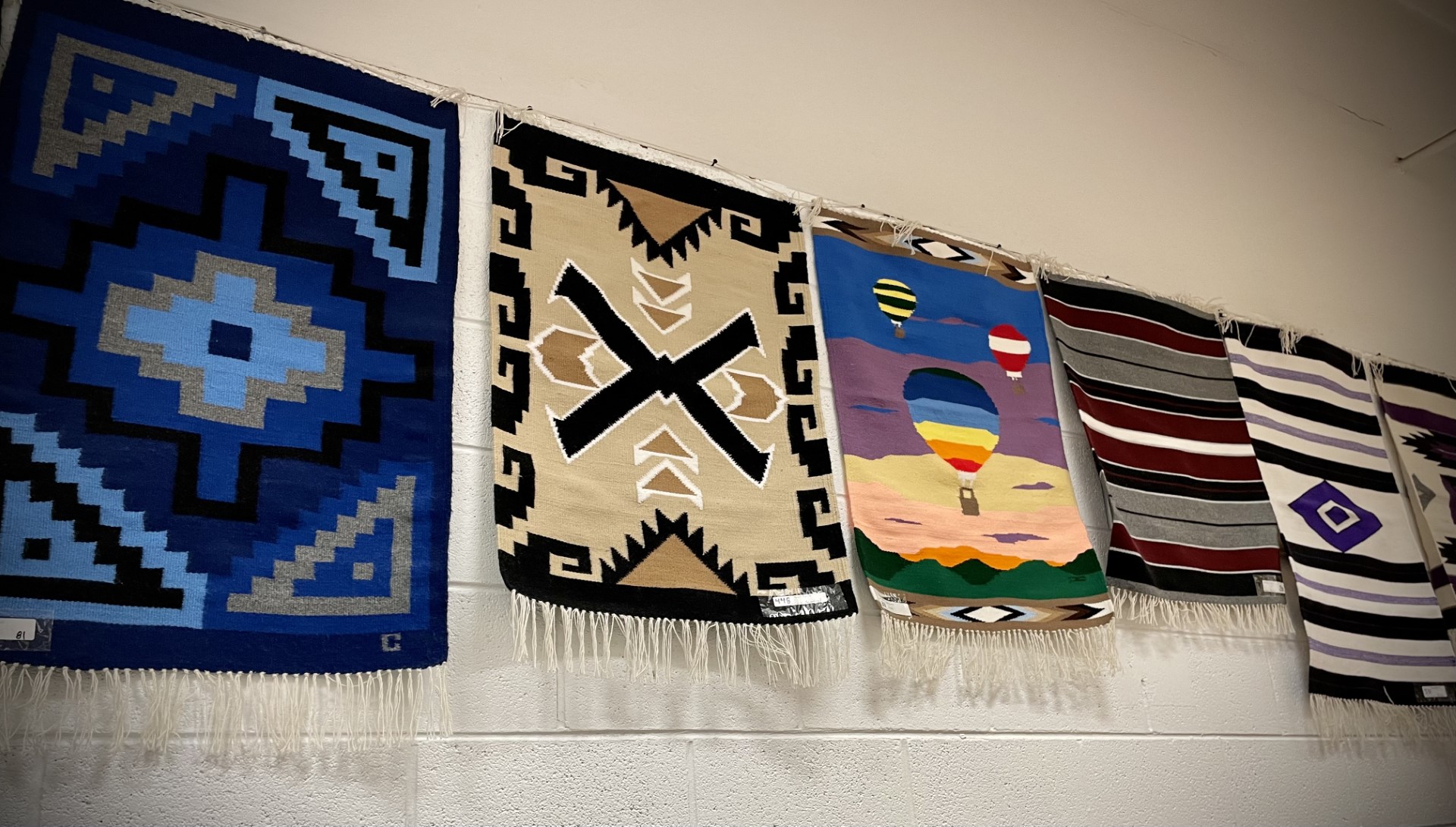 Woven rugs hung up on display