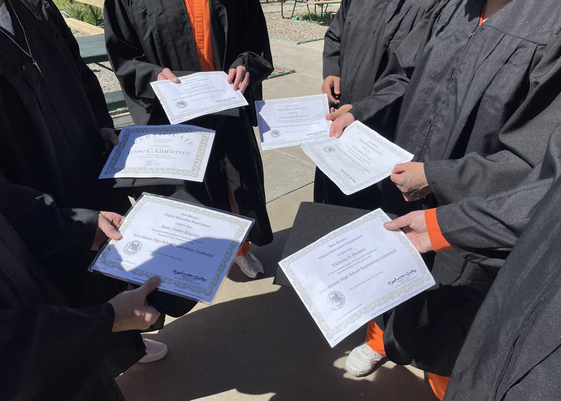 Inmates holding their diplomas